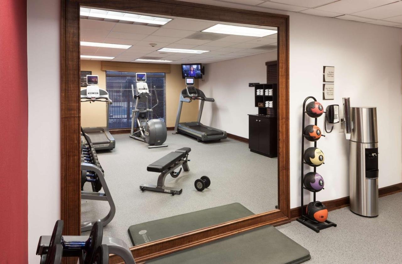 Small hotel gym with weights and workout equipment