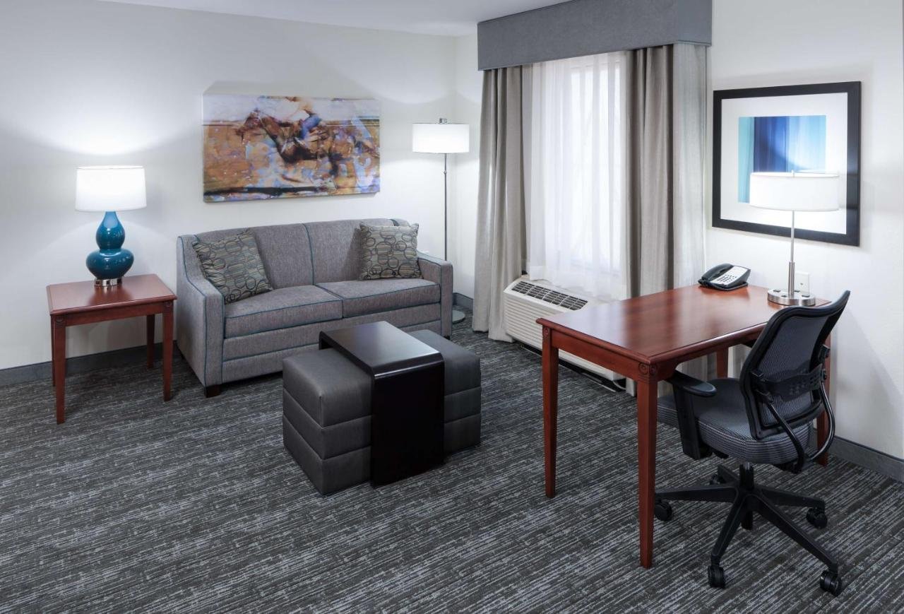 Hotel room with desk, couch, and armchair